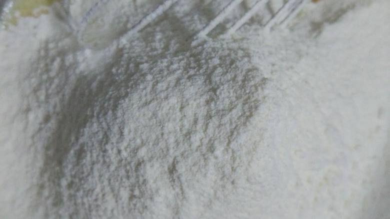 卡通玛德琳,蛋黄液里加入过筛的面粉,用手动搅拌器画Z字搅拌均匀