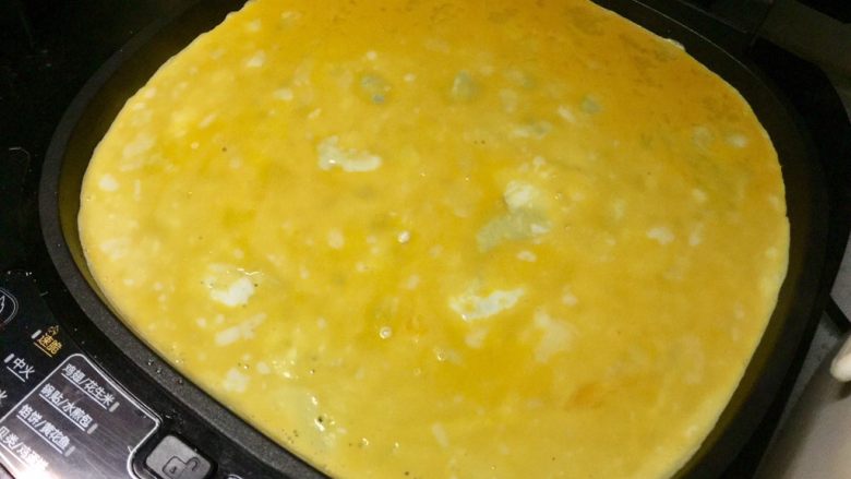 黄金黑米卷,把鸡蛋液翻去电饼铛,晃匀。