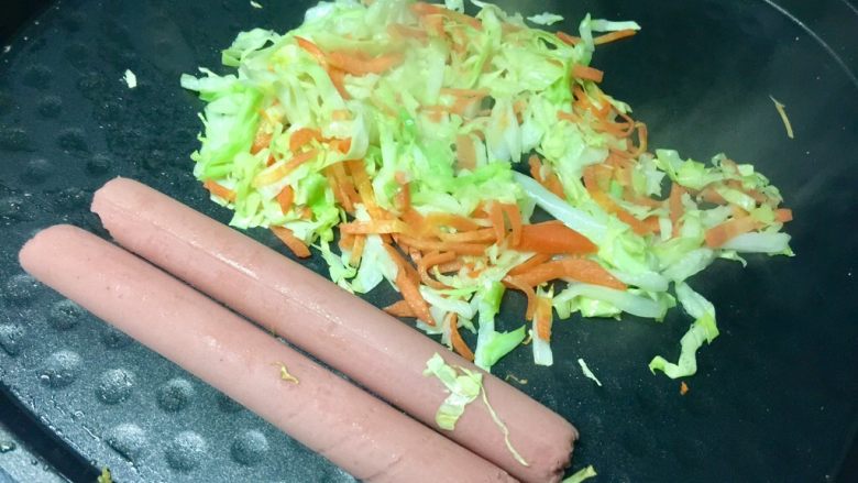 黄金黑米卷,两种蔬菜炒在一起,加适量盐调味,然后关火,把火腿肠用余温煎一下。