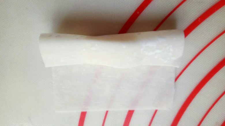 年味十足~香蕉糖果,将馄饨皮的一端对折。