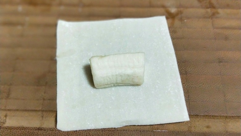 年味十足~香蕉糖果,取一张小馄饨皮,放入切好的香蕉块儿。