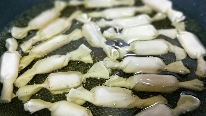 年味十足~香蕉糖果,锅中加入玉米油,油温4成时加入包好的香蕉糖果,中小火慢炸。