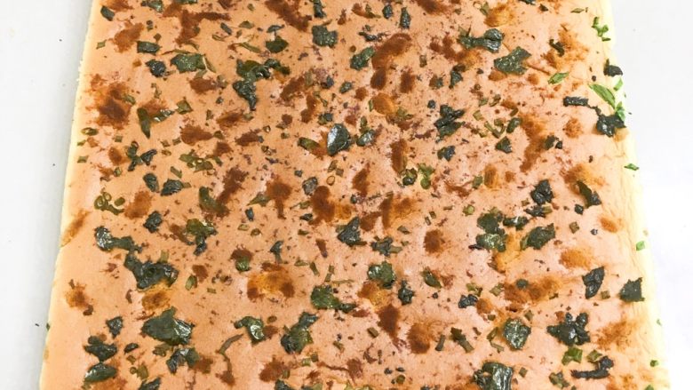 香葱肉松海苔蛋糕卷,周围用刮板刮一下,移至烤网上稍凉