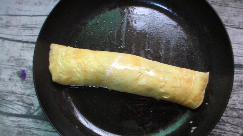炒饭版肉松长棍面包,卷成蛋卷,整好形,将边缘压紧,略煎定型出锅即可。