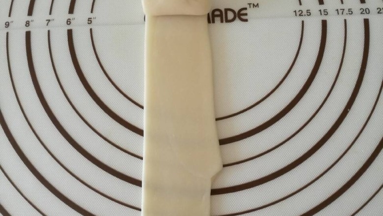 西瓜酥,醒好的酥皮竖向擀成长条,从上往下卷起醒20分钟