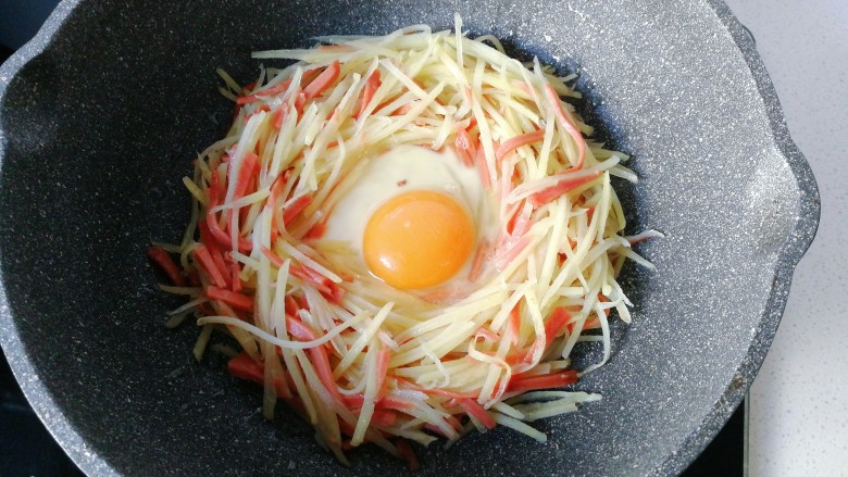 火腿土豆烘蛋,中间打入一颗<a style='color:red;display:inline-block;' href='/shicai/ 9'>鸡蛋</a>,小火慢煎;
