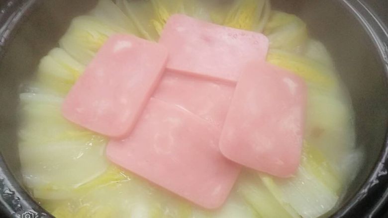 蛋汤焖煲娃娃菜,10分钟后放入少许油,摆好午餐火腿片