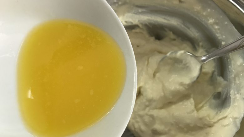 轻乳酪蛋糕,把黄油加入奶酪糊中,搅拌均匀。