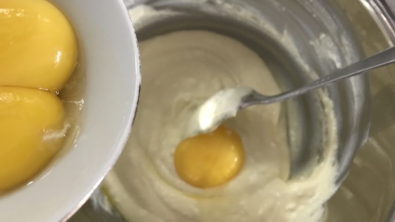 轻乳酪蛋糕,分三次加入蛋黄,搅拌均匀。