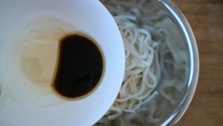 三合油拌面,把三合油倒入面条里,搅拌均匀。