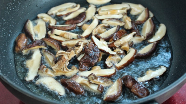 杂蔬香菇烧腐竹,锅中放油烧热后,倒入香菇炒出香味