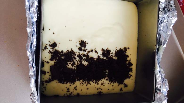 奥利奥重芝士,取出冰箱中冷藏的饼底,倒入一半奶酪糊,加入奥利奥碎,这个随心所欲了,看个人喜好加