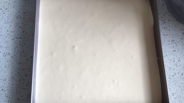 日式泡芙蛋糕卷,把蛋糕糊倒入28cm*28cm的不粘烤盘中,轻震几下排出大气泡