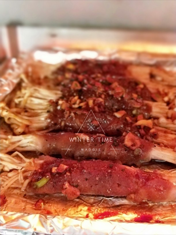 黑胡椒蒜香烤肥牛金针菇卷,烤箱预热,190度,先烤10分钟,再取出烤盘给肥牛卷翻面,现磨黑胡椒粒撒肥牛卷上,再烤5~7分钟左右即可取出。