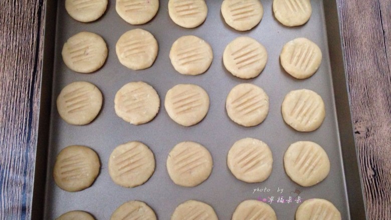 花生酱小饼干,直接用手揪一小块面团搓圆按扁放入不沾烤盘,然后用叉子在每个面团表面按一下按出花纹。我的面团每个大约10g左右,一盘烤不下,另外多出几个第二炉烤。