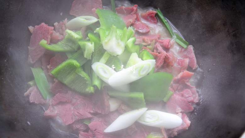 回锅牛肉炒青椒蒜苗 五香牛肉的新吃法,10分钟后拿去锅盖,倒入青椒和葱段及蒜苗叶子,大火收汁。