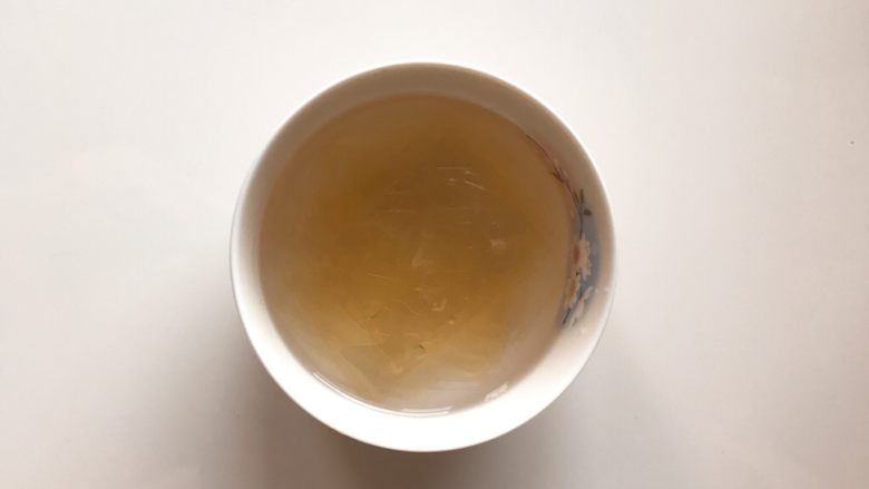 下午茶の草莓慕斯,将制作慕斯层的两片吉利丁片放入可以喝的冷水中泡软。(制作镜面的1片吉利丁片分开泡)