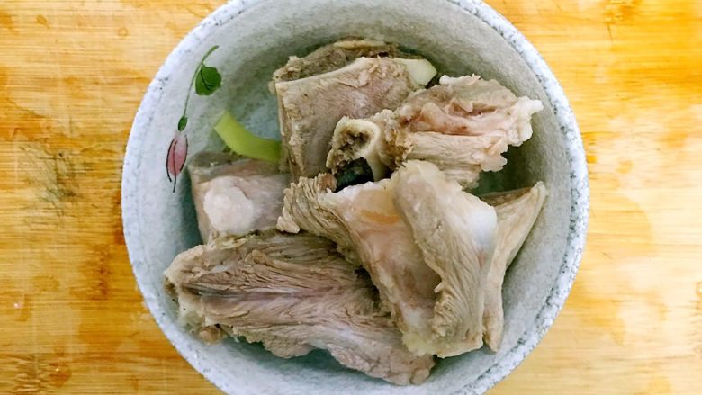 暖冬系列~滋补养生之红枣枸杞萝卜大骨汤,捞起猪大骨,用温水冲洗一下,洗去表面的脏东西