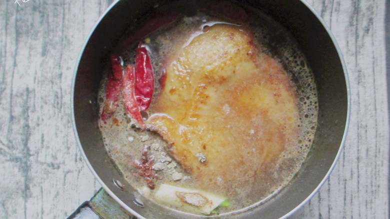 脆皮闷烧鸡腿,放入葱段、干辣椒、八角、姜片,加入一碗热水,调入盐、酱油大火烧开,煮十五分钟