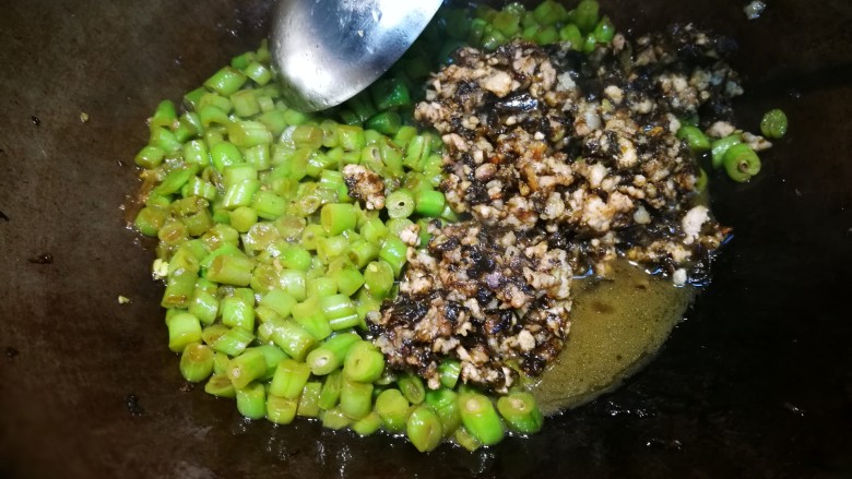 榄菜肉末四季豆,水收至三分之一左右时,加榄菜肉末,炒匀出锅