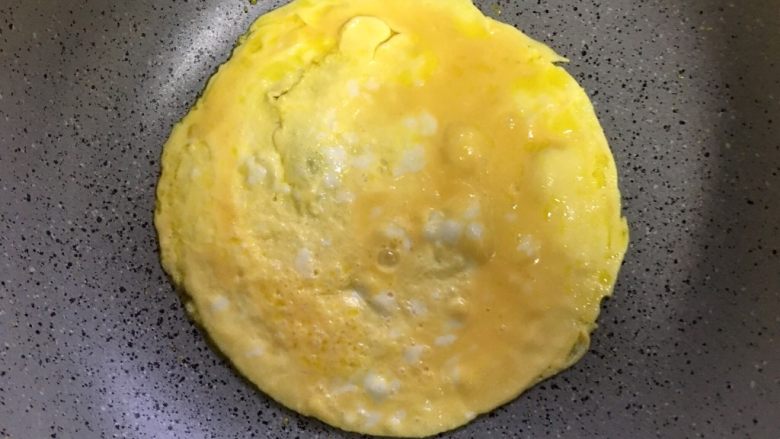 扬州蛋包炒饭,鸡蛋倒入锅中,蛋液还未凝固时
