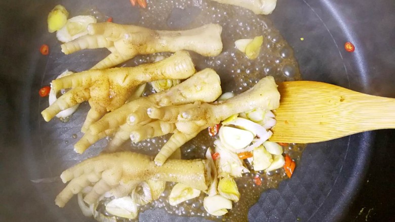 黯然销魂爪,锅中加入腌制的鸡爪进行翻炒;