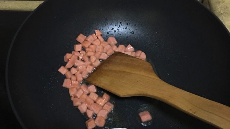 火腿番茄意面,锅里导入油,把火腿肠炒香。