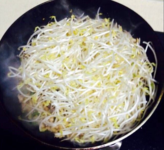 绿豆芽炒肉,倒入豆芽,大火快速翻炒。