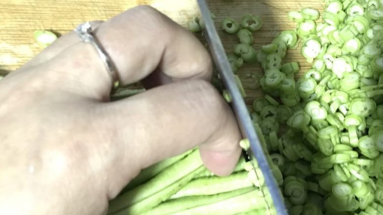 黑胡椒豇豆菜圃蛋,切末的时候,要如图弯曲手指,刀一面贴着手指,这样才不会切到手哦……