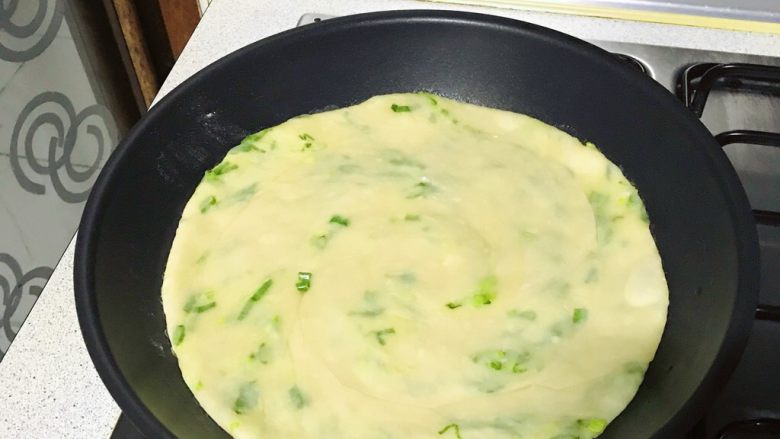 葱油饼,饼的染色慢慢变化了,这时底部已煎好了。