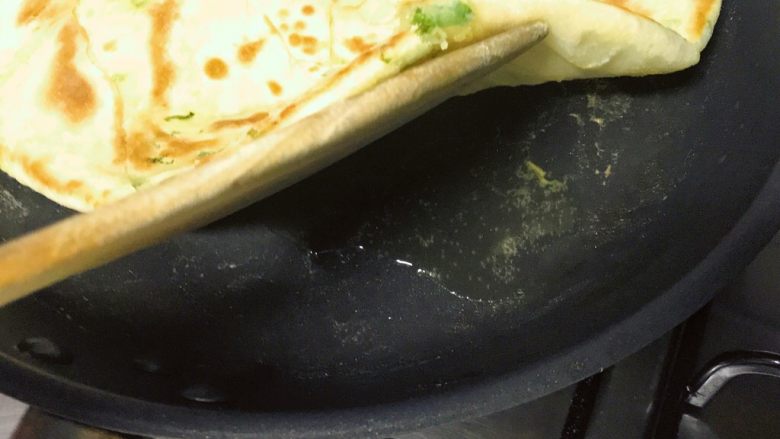 葱油饼,翻面,锅底在倒入一点油,再次旋转饼,目的同上。