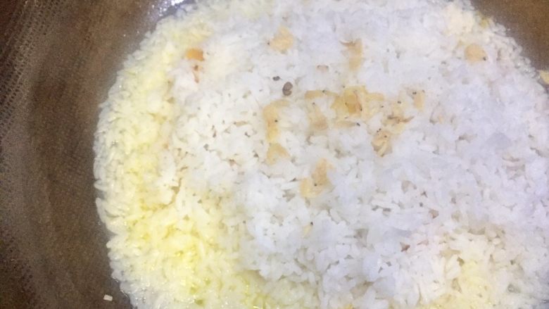 香甜南瓜虾米黄金饭,水开了后,中小火加盖闷烘饭,这是五分钟后,南瓜的颜色已经出来了,米饭也染黄了,米饭边缘还看的见有一点水