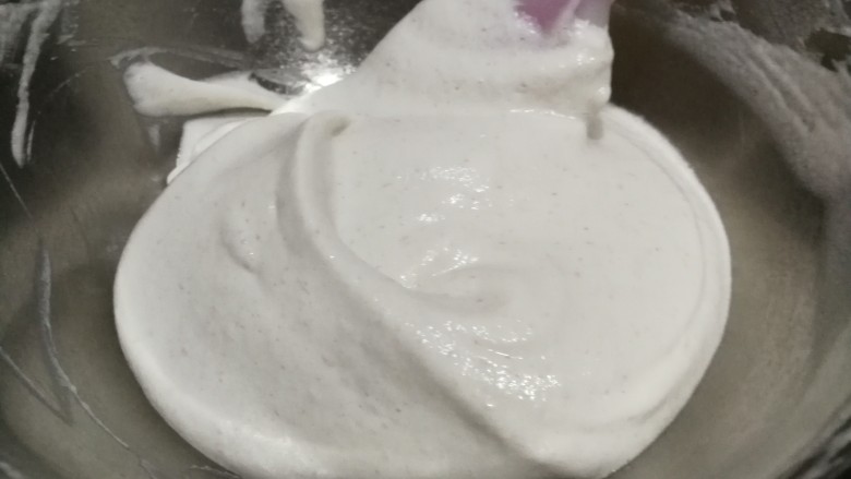 香蕉溶豆,用刮刀翻拌均匀,注意翻拌手法以免蛋白霜消泡,手法是刮刀呈J型从2点钟方向起拌,至8点钟方向收起,右手用刮刀一边拌同时左手转动打蛋盆,直至面糊全部拌匀