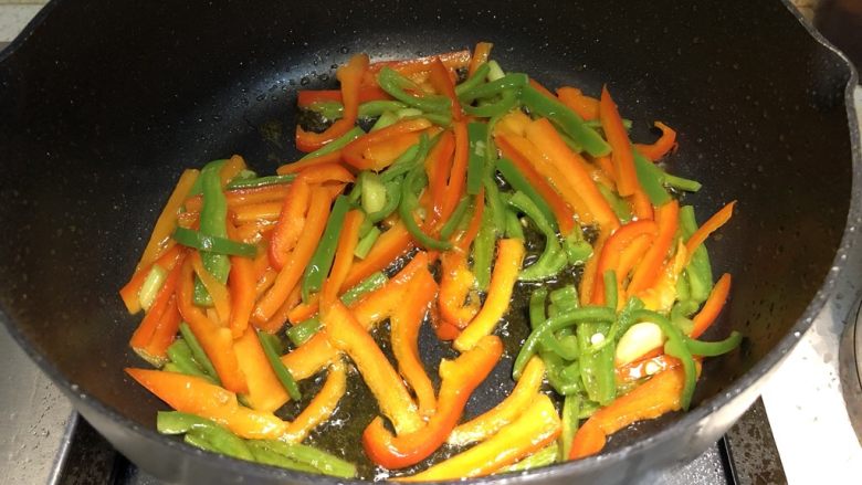 家常小炒|双椒豆腐干,锅内先倒入适量食用油,油热后,倒入葱段爆香,倒入红椒丝和青椒丝翻炒