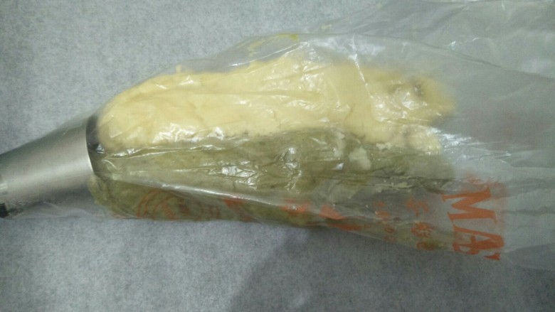 雪花双色曲奇,将两种颜色的面团分别放入裱花袋的两边并推送到裱花嘴处,多套一个裱花袋避免花嘴脱落。