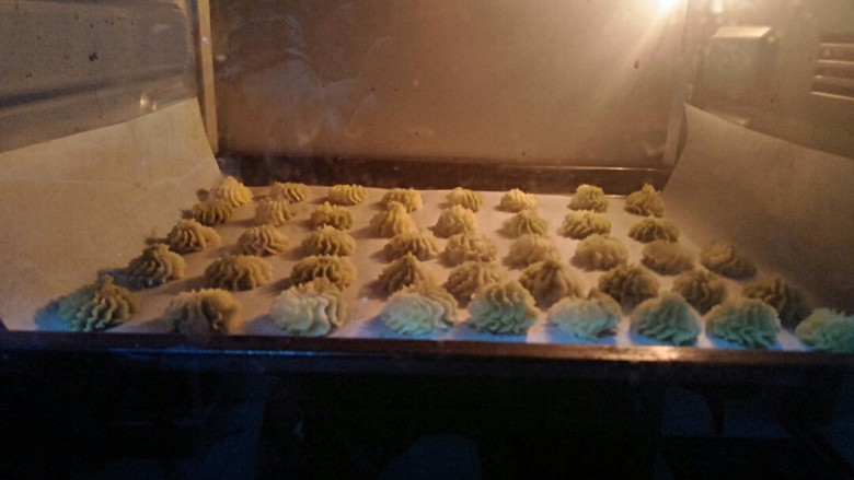 雪花双色曲奇,放入预热好的120度的烤箱烤二十五分钟,烤箱温度根据自家的调节。烤好后在烤箱焖五分钟才拿出来。