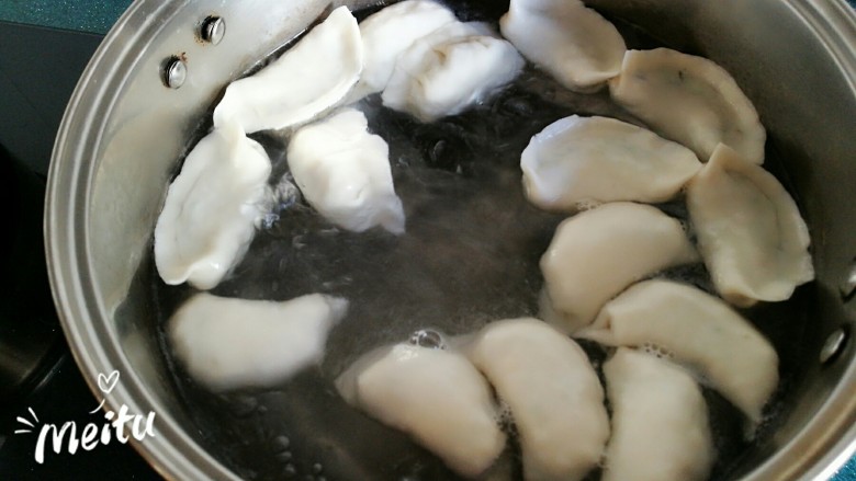 豆腐芹菜粉丝素饺子,煮锅水开后放入饺子,用漏勺深入锅底,轻轻搅动几下,防止饺子粘在锅底。