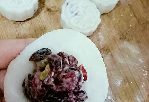 蔓越莓冰皮月饼♧,面皮压扁,包馅,团圆后放在熟糯米粉的案板上,月饼模内放入少量熟糯米粉,接下来压模了。