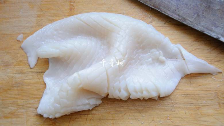 鱿鱼卷爆炒洋葱青辣椒 ,再将鱿鱼旋转90度,改为竖直方向下刀,直切,依然不要切透,间距控制在3-5毫米。
