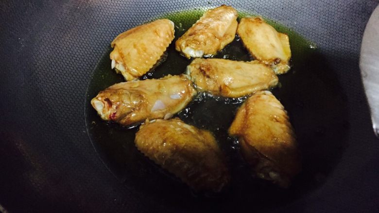 可乐鸡翅,腌制完毕,锅中放入适量的油小火加热放入鸡翅两面炸至稍微变色即可。