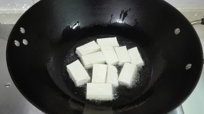 葱香红椒老豆腐,热锅热油,放老豆腐下锅中火煎