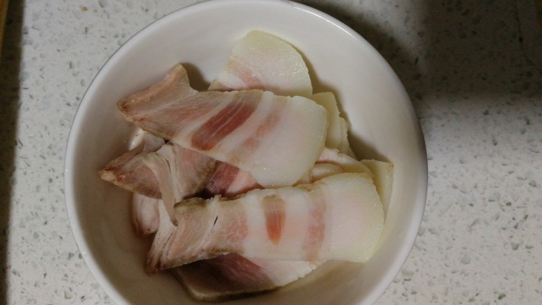 回锅肉(蒜香炒回锅肉),将蒸熟的五花肉放在冰箱里冷冻10分钟,将其切片,每片(2-3mm)