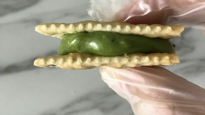 抹茶芒果丁牛扎饼,之后盖上另一片饼干,大拇指和食指稍微用一点力压一下,让糖分布均匀一些,别太大力,饼干会碎的。