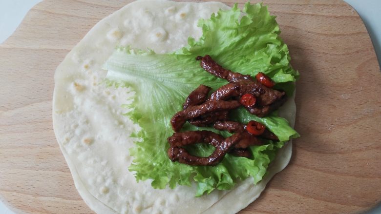 嫩牛肉卷饼,取一张烙好的饼,放上一片<a style='color:red;display:inline-block;' href='/shicai/ 92833'>生菜叶</a>,放入牛肉,然后卷起来便可以吃了