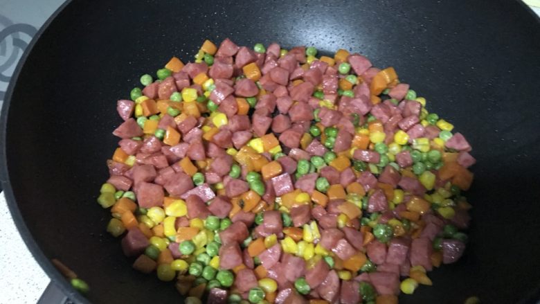 什锦炒饭,翻炒均匀,炒出香肠的香气,且变得饱满。