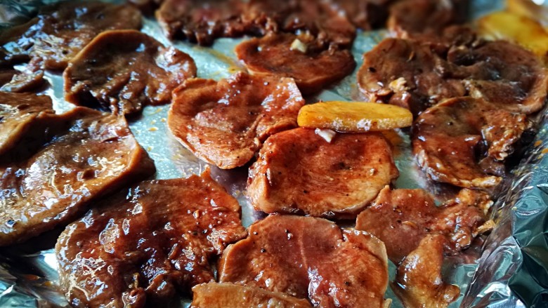 创意菜~香烤黑椒口条,将腌好的猪舌片摆放在烤盘中