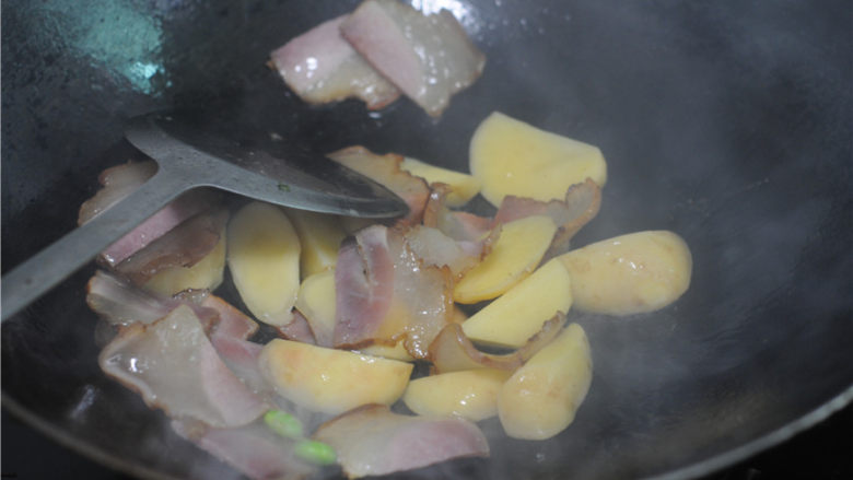 腊肉排骨放,倒入土豆块和排骨,稍微翻炒几下