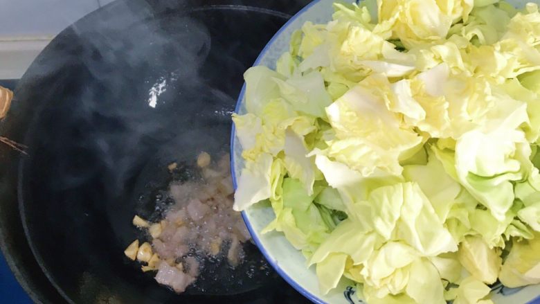 蒜香茄汁五花肉手撕圆白菜,炒至肉变色变微焦，倒入包心菜爆炒