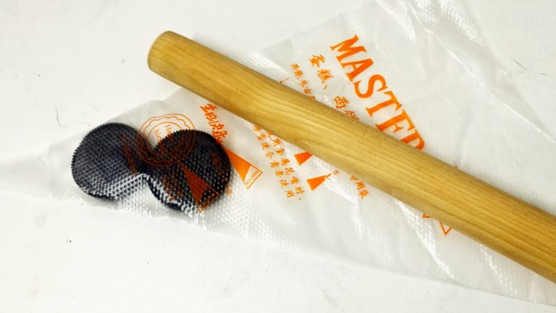 简单易学—8寸芒果慕斯免烤蛋糕,奥利奥饼干,用刀刮去中间夹心的糖霜,放入裱花袋,借助擀面杖碾碎,也可直接买饼干碎来用。