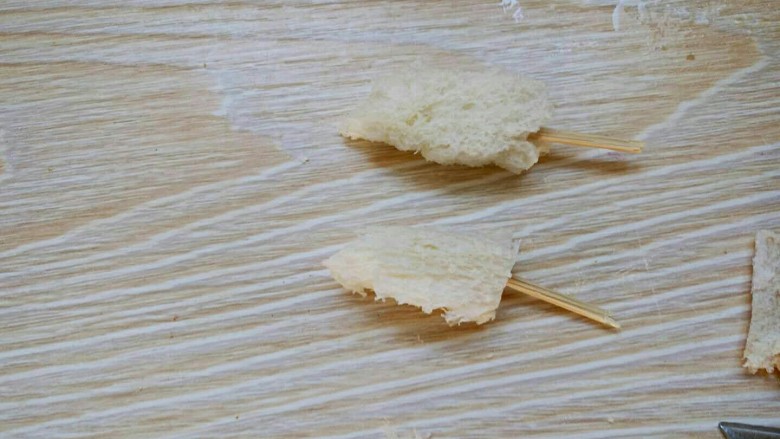 小兔土司卷,你和美好的早餐只差一个萌宠,在准备一片土司,切出两个椭圆形,在用牙签扎起,插在土司卷的上面。